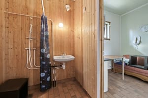 Enkelt bad med dusj og toalett, samt hvilerom/kontor i det tidligere fjøset