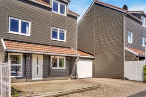 Boligen har et pent inngangsparti med platting og gårdsplass samt parkering i egen garasje
