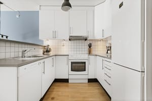 Kjøkkenet inneholder hvitevarer som oppvaskmaskin, kombiskap og komfyr med steketopp 