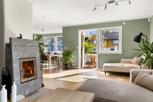 På stuen har man en moderne klebersteinspeis som i tillegg til peishygge varmer godt på kjøligere dager
