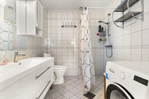 Flislagt baderom med gulvvarme, opplegg for vaskemaskin, dusjnisje, toalett og servant i servantskap. Ekstra oppbevaring i veggskap