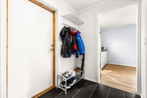 Entré med plass til å henge av seg yttertøy og sko. Flislagt gulv med gulvvarme