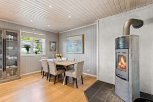 Kjøkkenet har koselig spisseplass med flott vedovn