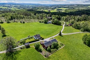 Tunet ligger på to sider av veien, der våninghuset med hage ligger solrikt plassert på sydsiden.