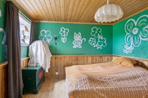 Soverommet i underetasjen i kårboligen har paneltak og brystningspanel.