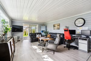 Kjellerstuen i kårboligen er romslig med utgang til en steinsatt uteplass og fin hage.