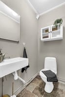 Vegg-i-vegg med badet er det et separat wc-rom med toalett, servant og speil 