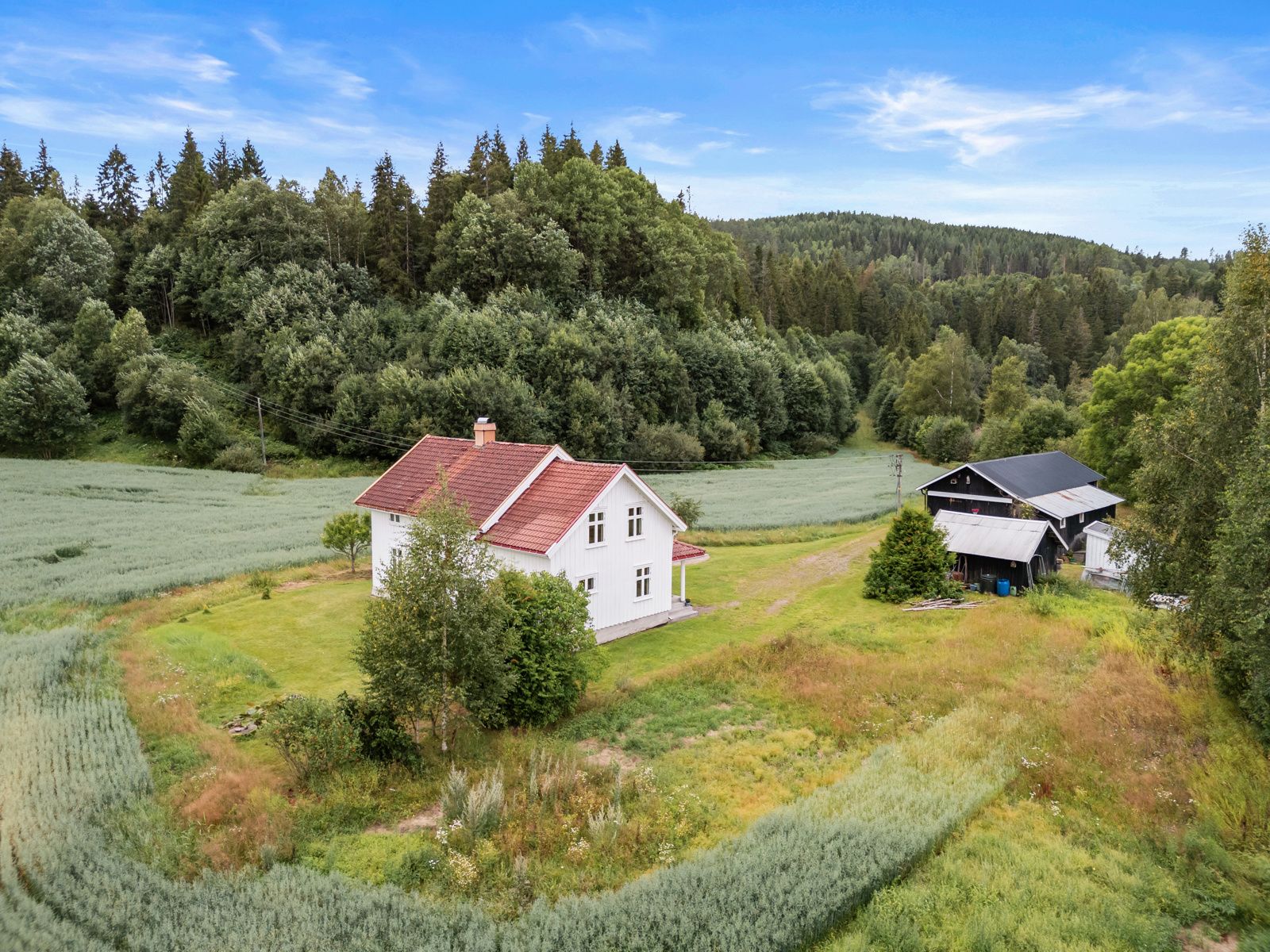 Omfatter tunflaten med våningshus, hønsehus, redskapshus, garasje, uthus og gårdsplass.