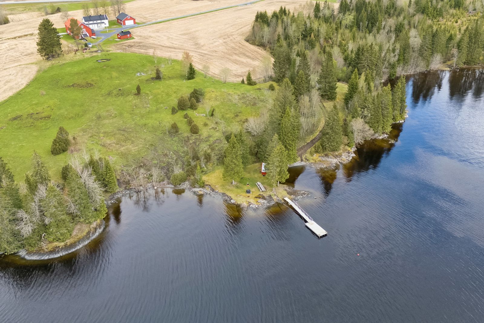 Naust og flytebrygge rett nedenfor tunet