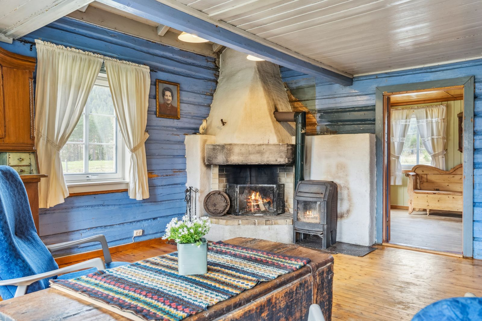 Med både vedovn og åpen peis får man det lunt og godt i den ene stuen i kårboligen.