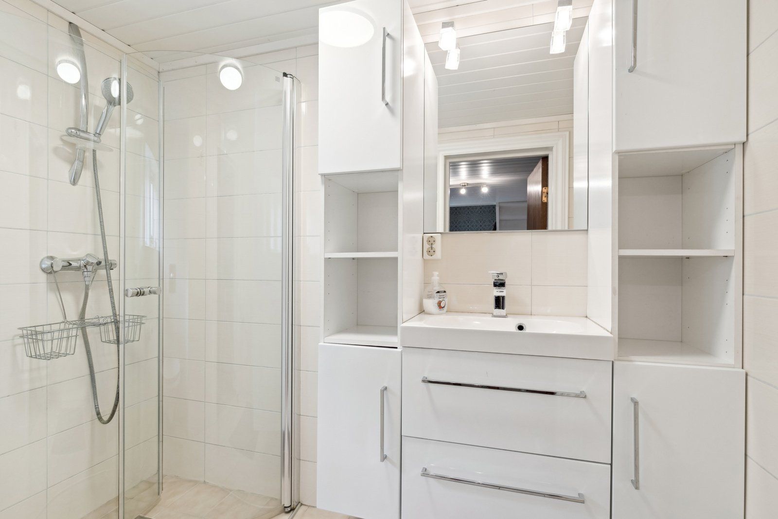 Badet i 1. etasje med dusjhjørne og en pen innredning
