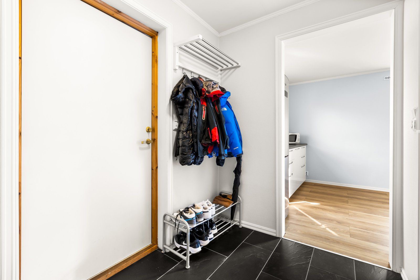 Entré med plass til å henge av seg yttertøy og sko. Flislagt gulv med gulvvarme