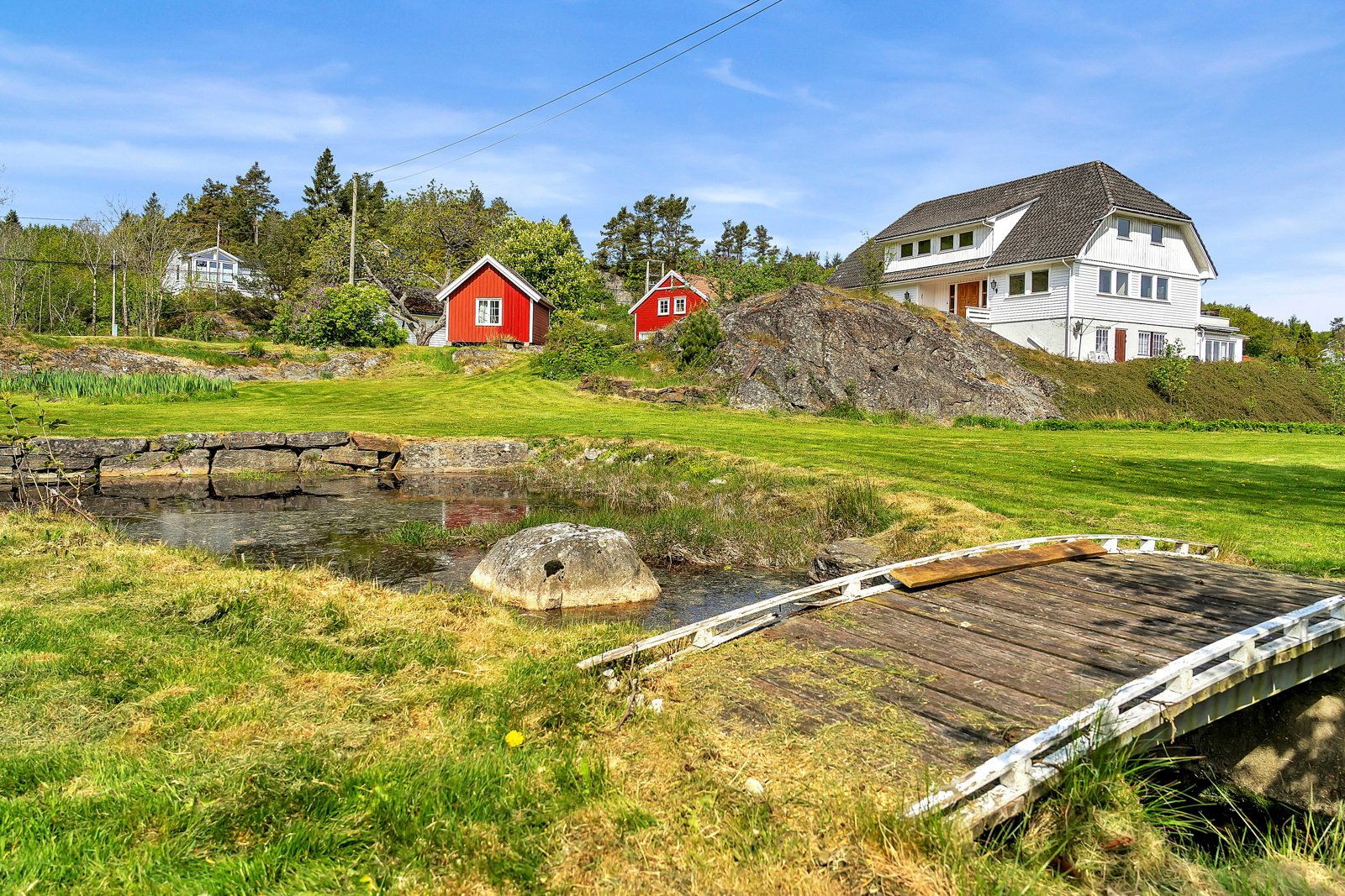 Det er en egen dam på eiendommen med en bekk som renner gjennom tomten.