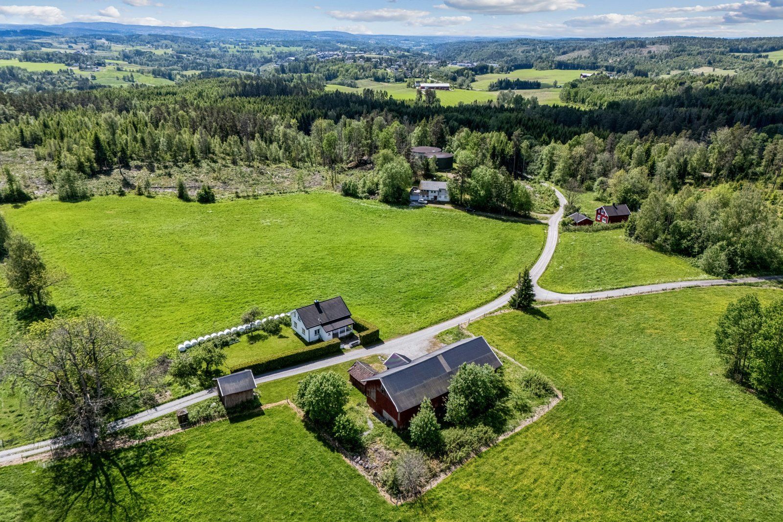 Tunet ligger på to sider av veien, der våninghuset med hage ligger solrikt plassert på sydsiden.