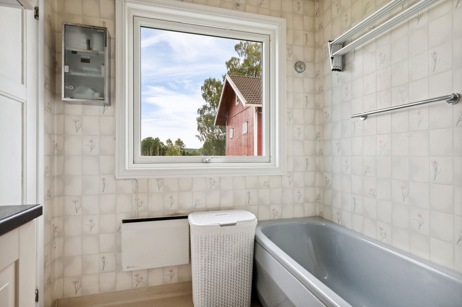 Badet nede er et kombinert bad/vaskerom med badekar, utslagsvask og grovkjøkken.