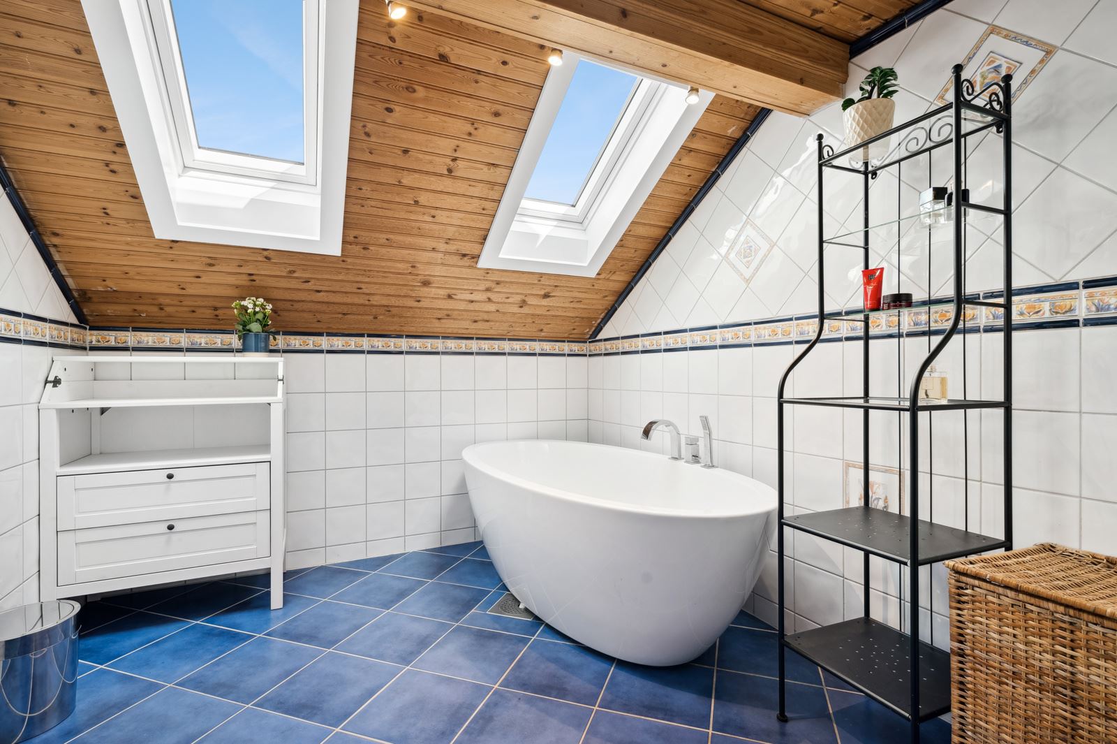 Badet oppe er helfliset, utstyrt med både dusjkabinett og flott badekar.