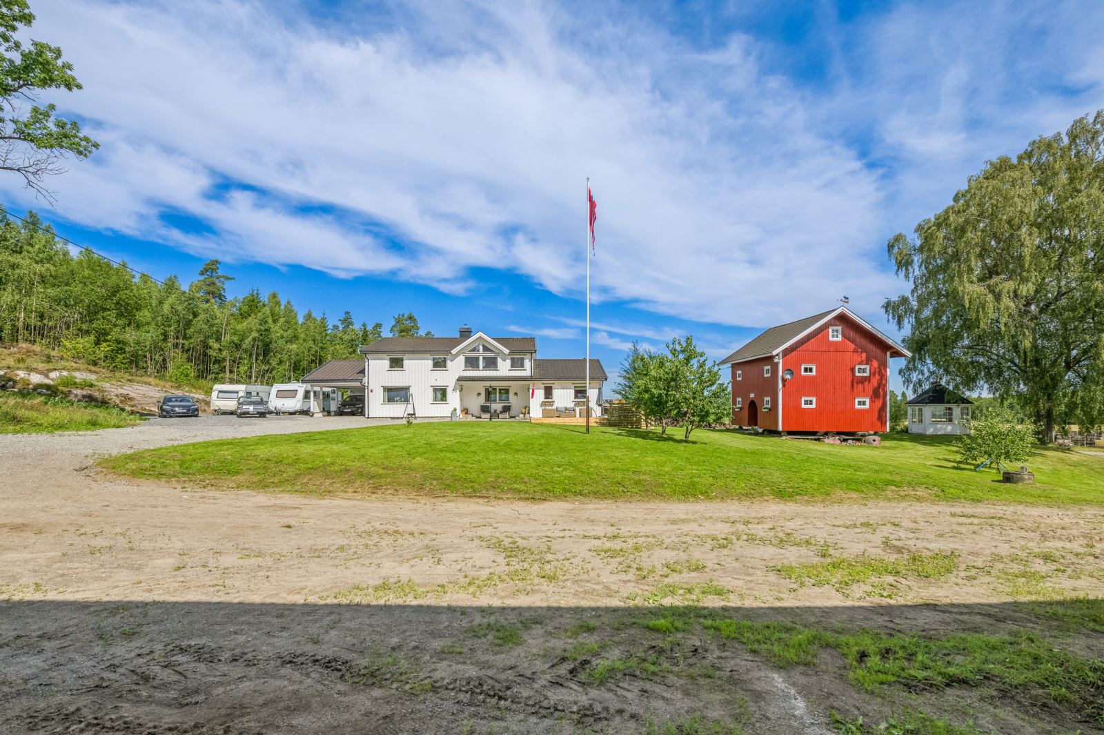 Gården har et åpent, ryddig og solrikt tun, flott opparbeidet med beplantning, gruset gårdsvei og store grøntarealer.