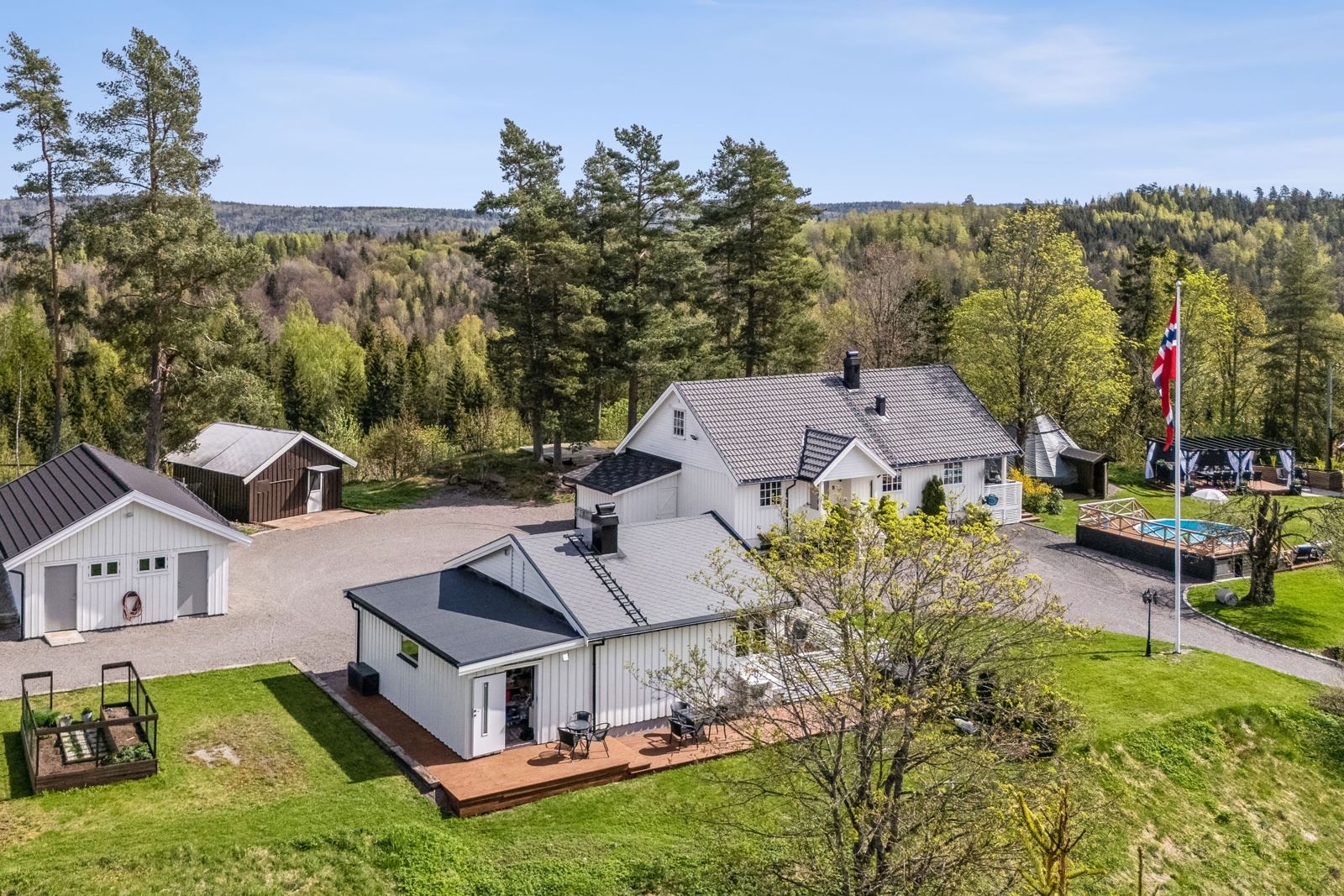Tunet er innholdsrikt og består av en enebolig med 3 soverom og full kjeller, anneks med bostandard, dobbel garasje med 2 baderom, snekkerverksted, stall, basseng m.m.