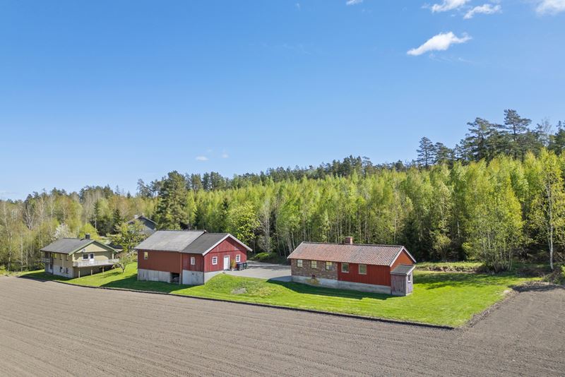 På eiendommen er det et våningshus, en låve med tilbygd garasje, snekkerverksted og et vognskjul.