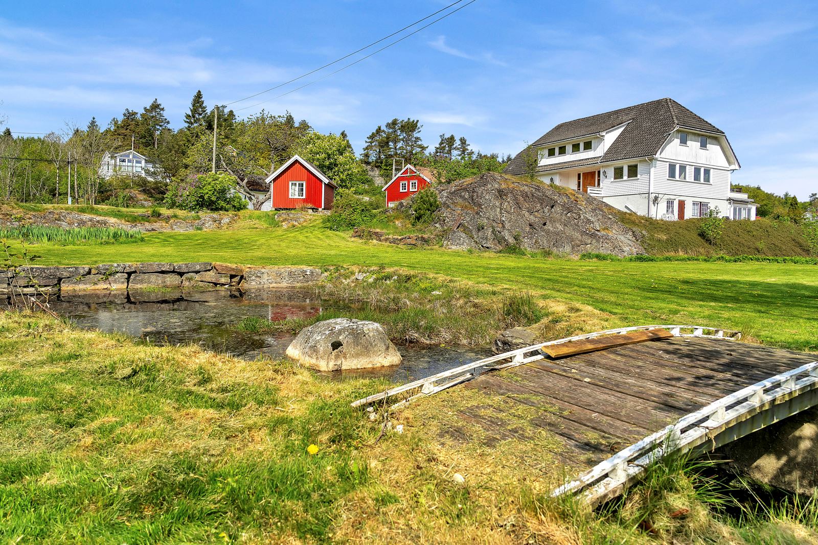Det er en egen dam på eiendommen med en bekk som renner gjennom tomten.