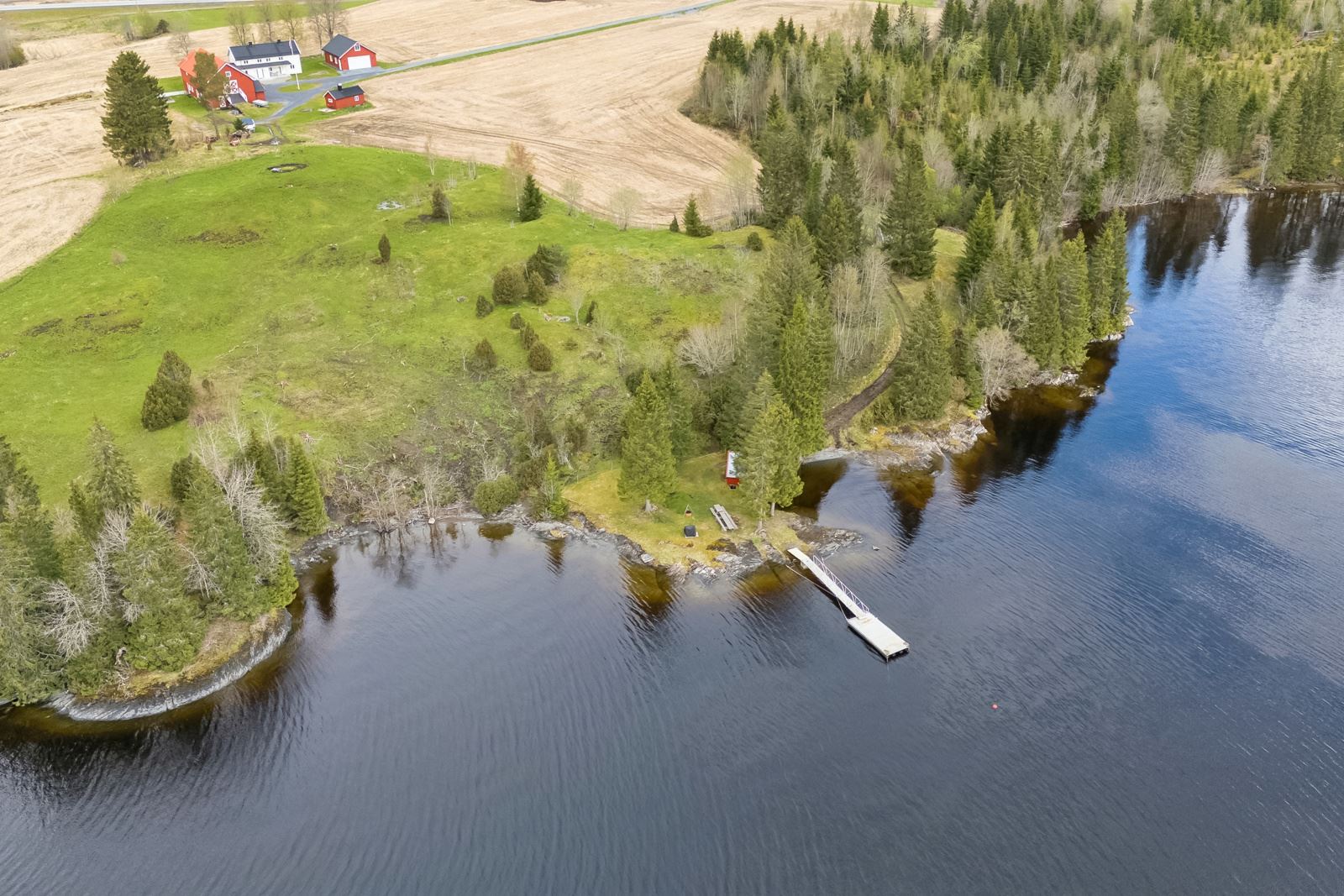 Naust og flytebrygge rett nedenfor tunet