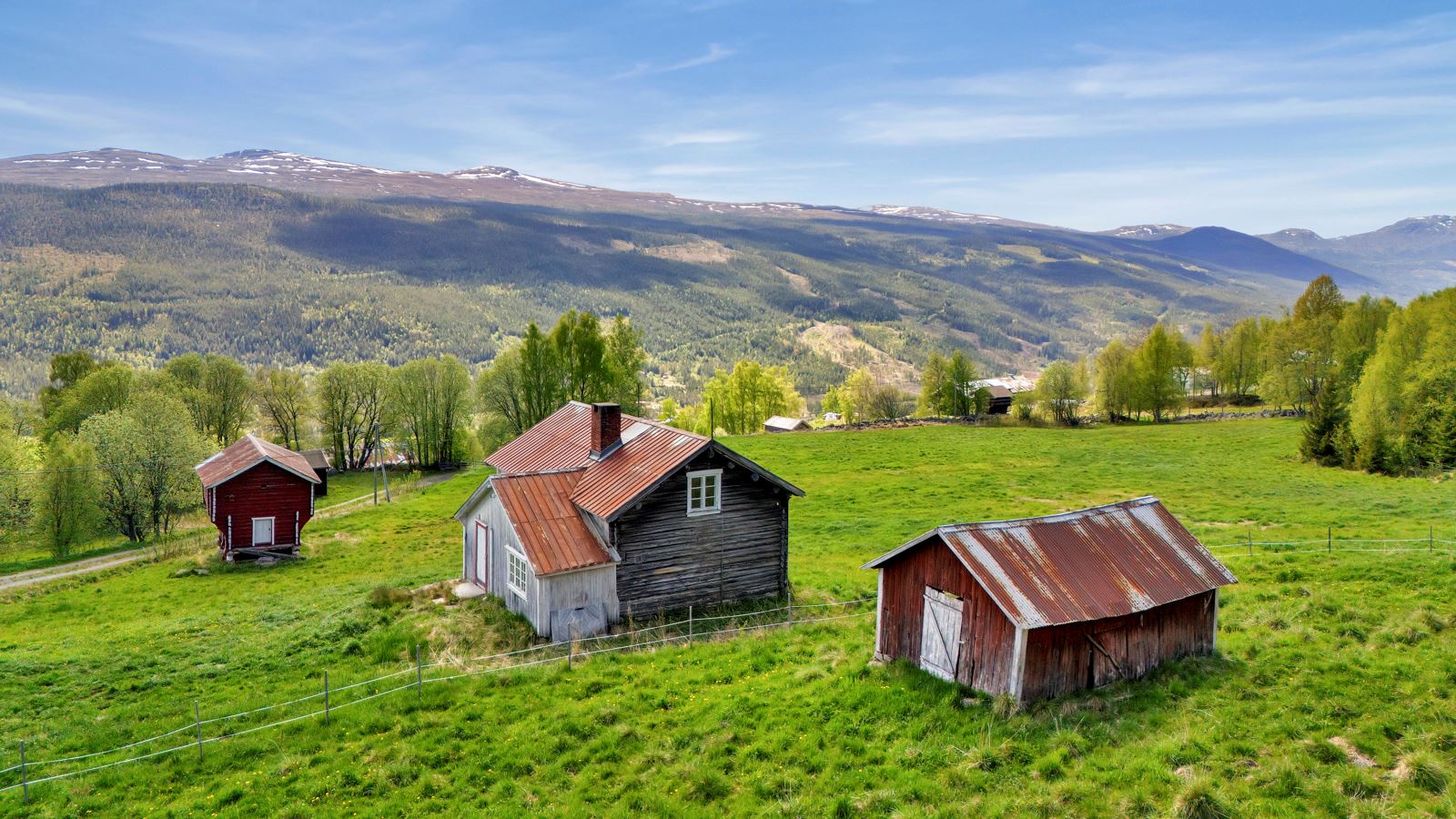 Oversiktsbilde av tunet ? idyllisk beliggende med åpen utsikt over dal og fjell.