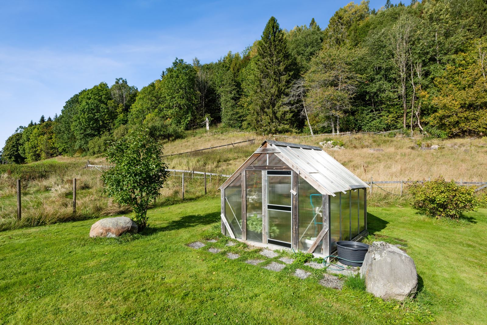 Hyggelig uteplass med drivhus utenfor Solliveien 119
