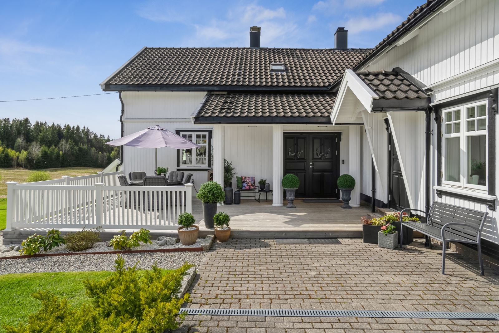 Våningshuset har en fin terrasse ved inngangen til hoveddelen og bryggerhusdelen.