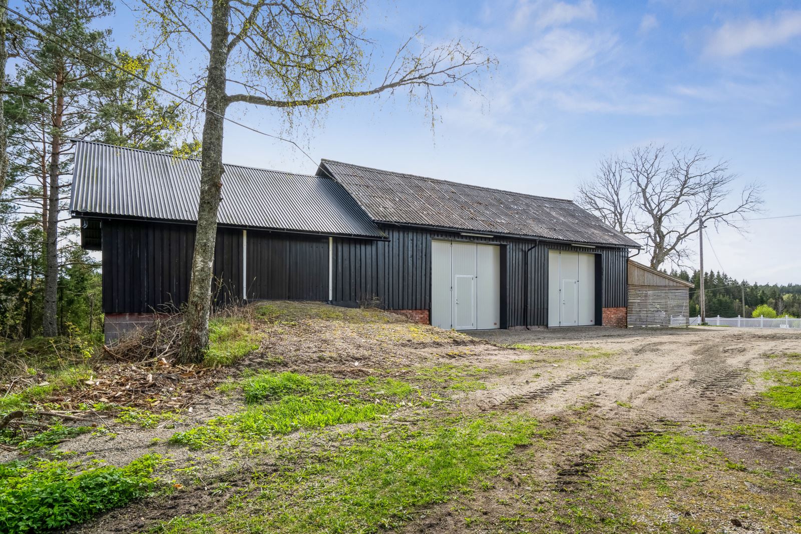 Et velholdt vognskjul fra 1980 ble tilbygd med en trippel carport i 2020 og malt opp i 2024.