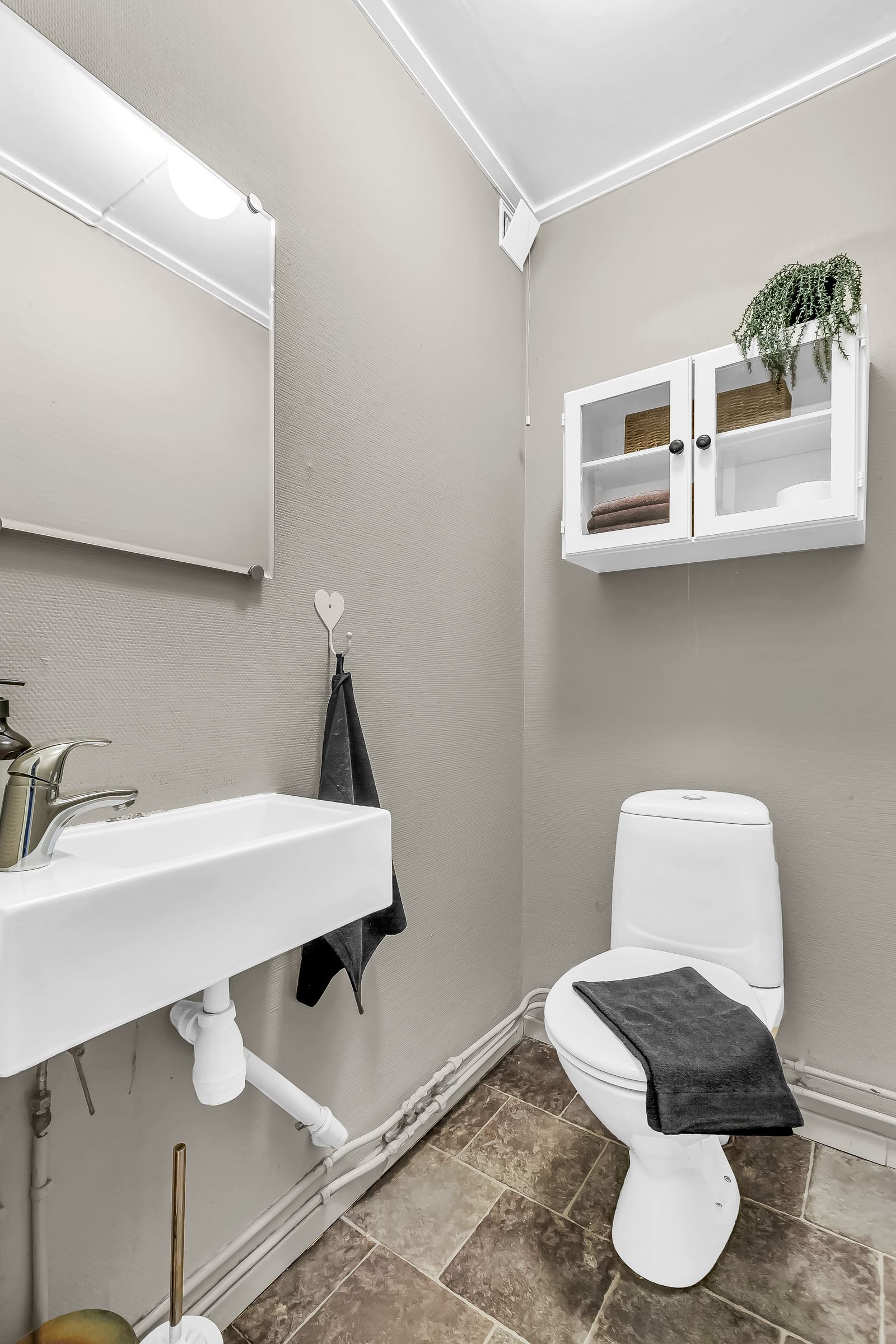 Vegg-i-vegg med badet er det et separat wc-rom med toalett, servant og speil 