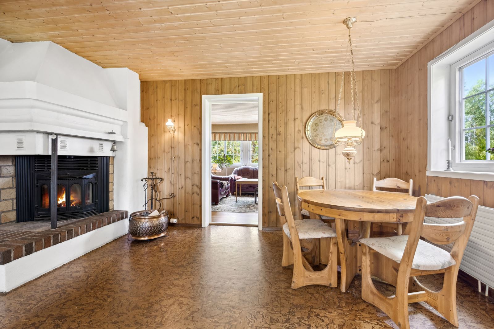 I den ene enden av det koselige kjøkkenet er det spiseplass og en stor peis med innsats som gjør det ekstra hyggelig.