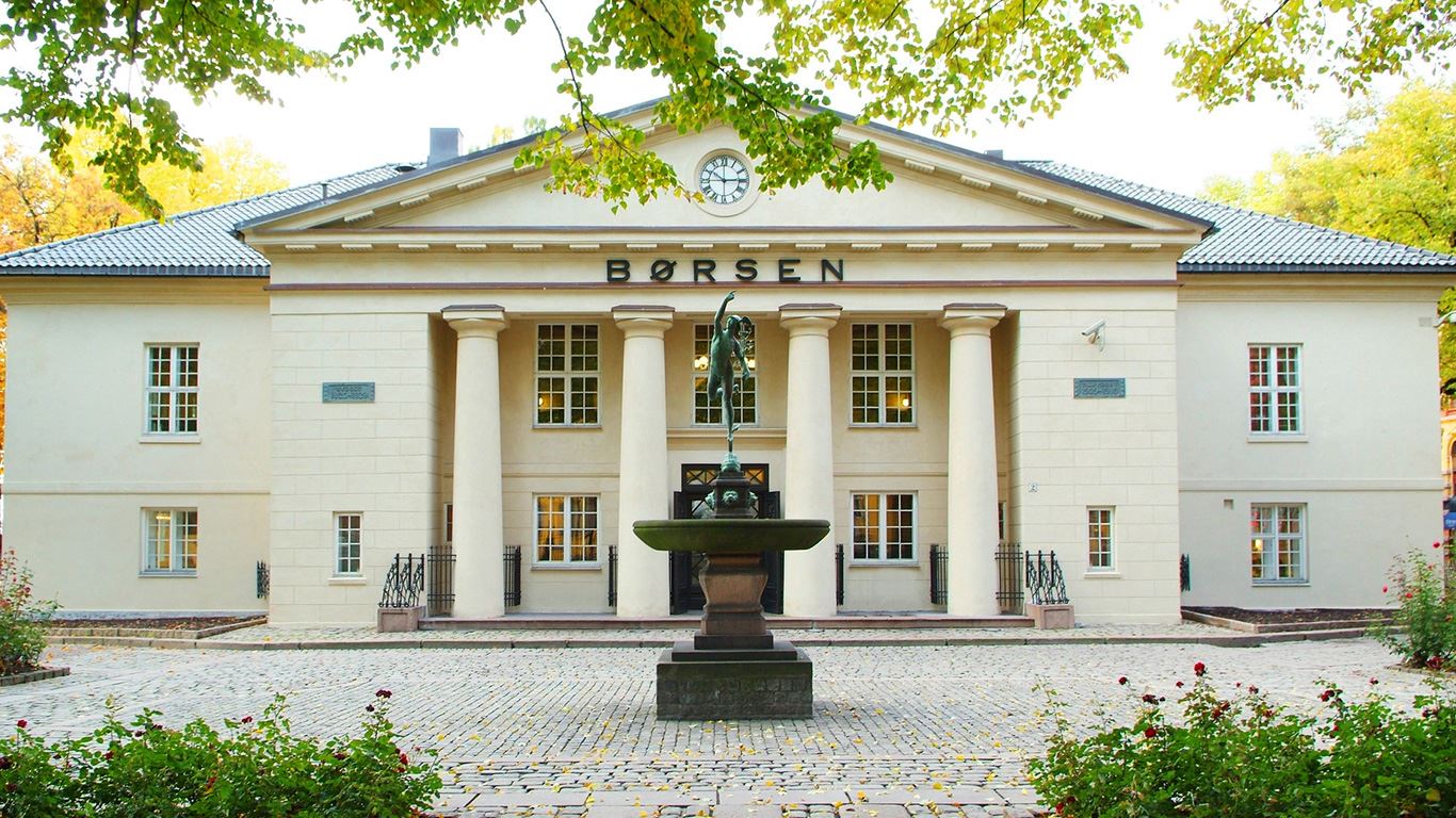 Oslo Børs med statue og grønt løvverk i front