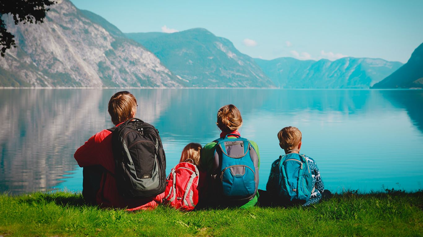 Foto. Familie sitter ved en innsjø