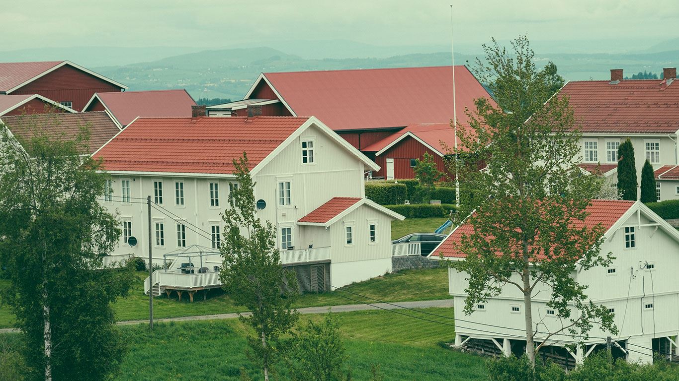 En rød husvegg med ett vindu med blomster i.