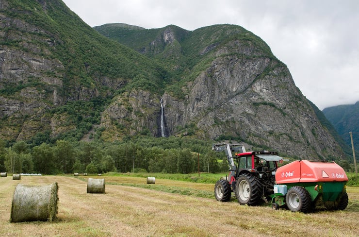 Traktor og høyballer. Foto.