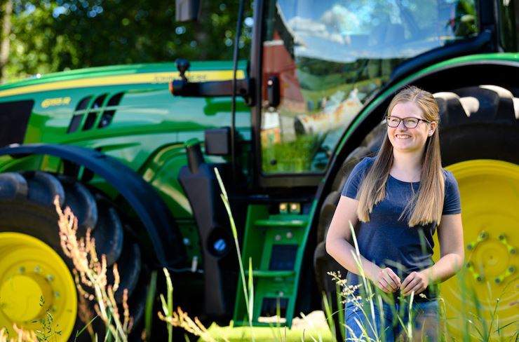 Illustrasjonsbilde: Jente foran ny grønn traktor.